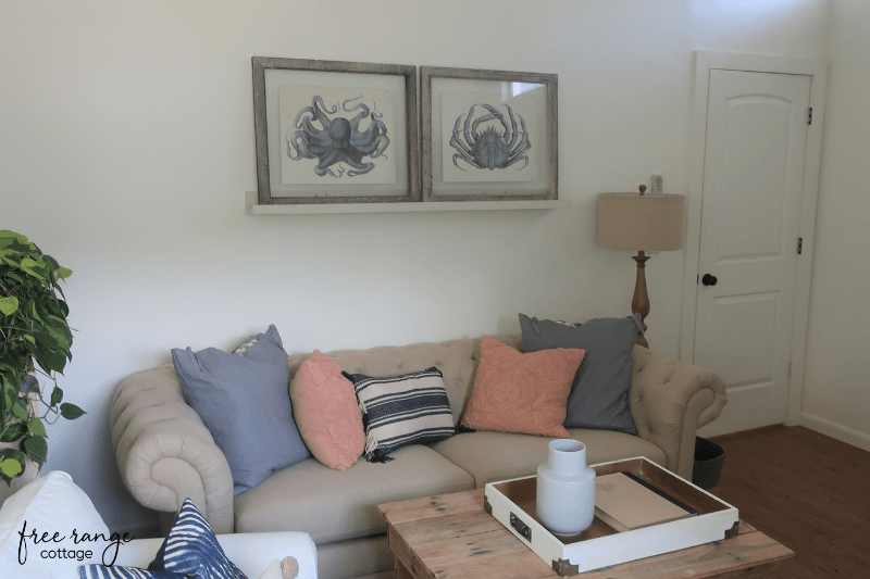 Sofa with pictures above and throw pillows