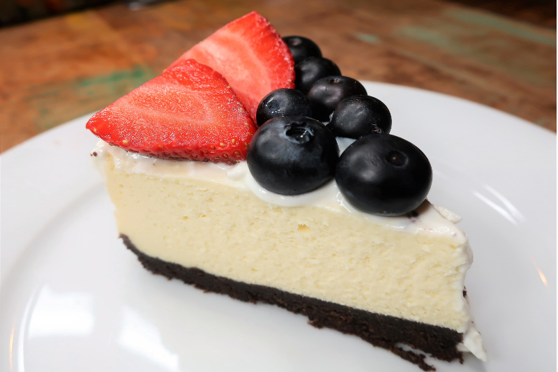 slice of cheesecake with blueberries and strawberries topping