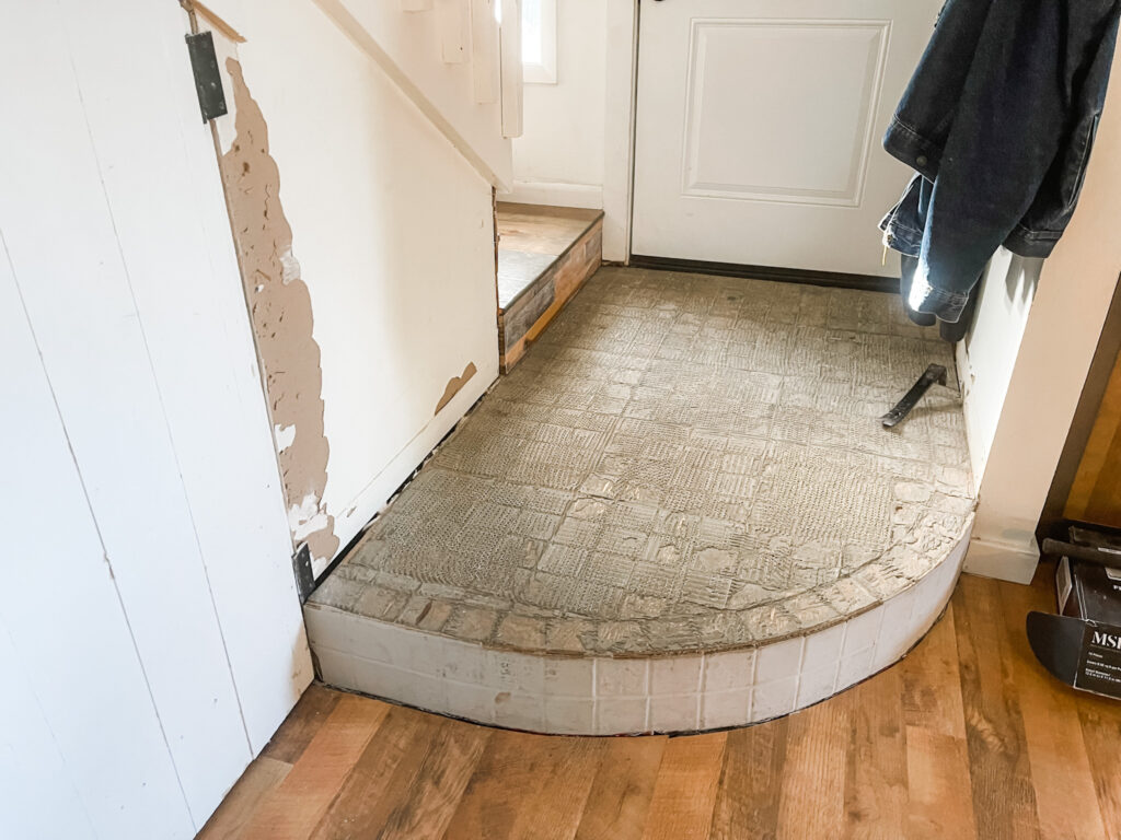 Before of small entryway. Dated tile and repairs needed.