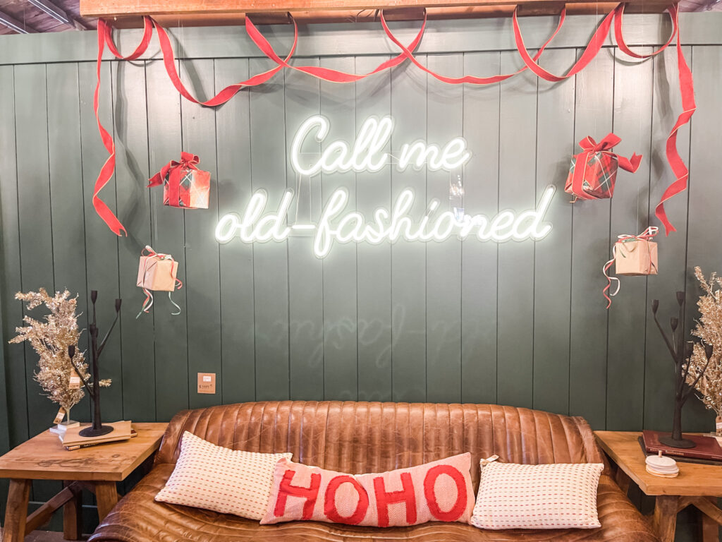 Ho Ho Ho pillow on sofa below neon "call me old fashioned" sign