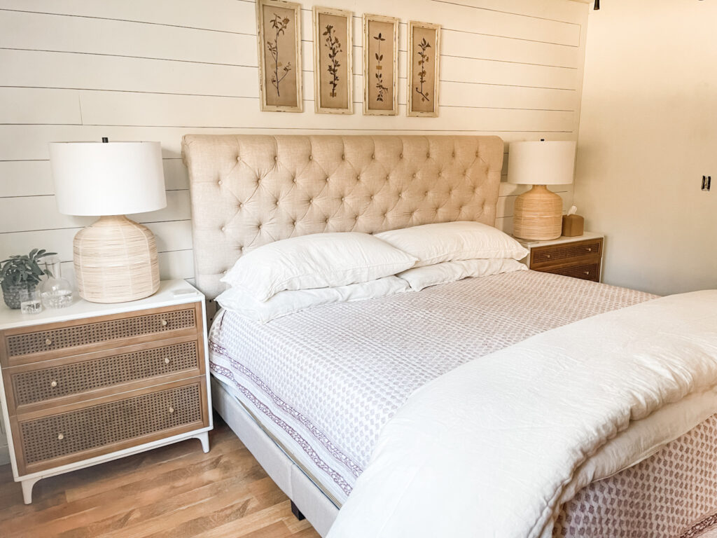 bedroom with two chest of drawers, lamps, artwork above bed