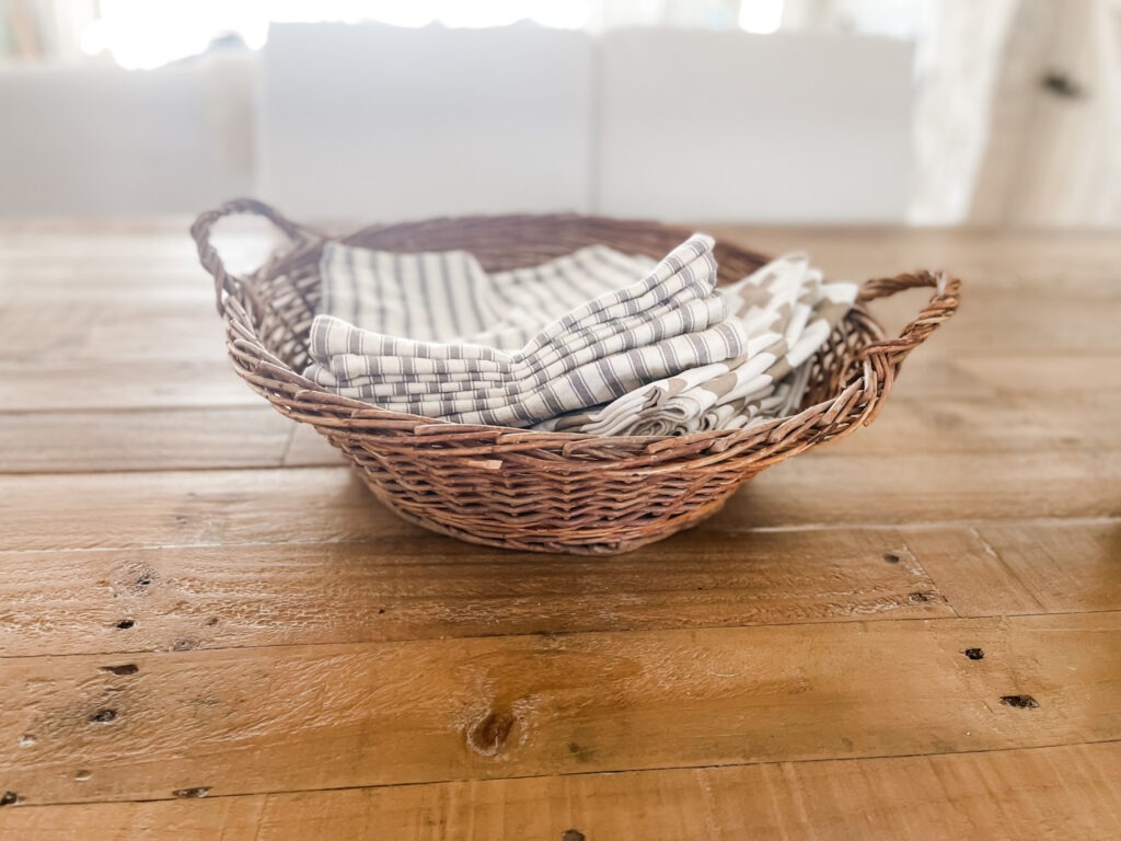 Cloth napkins in vintage basket on reclaimed wood table