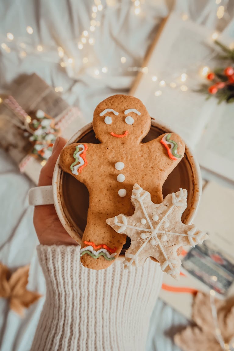 A warm gingerbread man and snowflake cookie placed on a cozy mug, perfect for winter festivities.