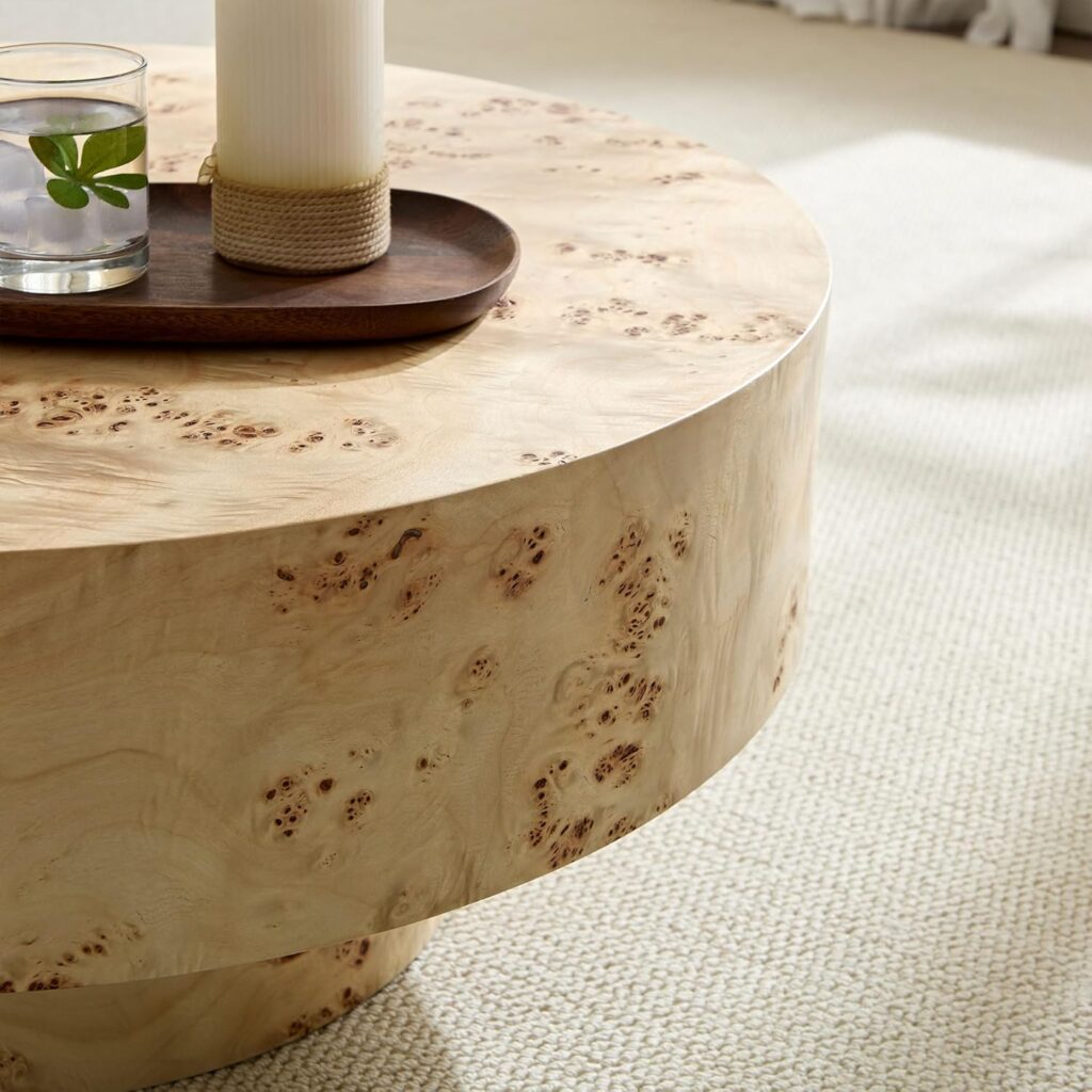 Light wood burl wood round pedestal coffee table. Accessorized with a candle and a tray